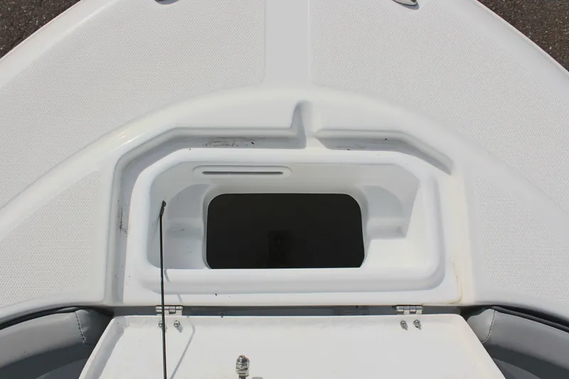 Slide: The Image of 2024 Clearwater 2200 CC boat storage compartment, open lid, white interior. - 24