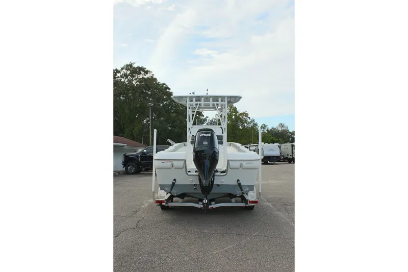 Slide: The Image of 2024 Clearwater 2200 CC boat, rear view with outboard motor, parked outdoors. - 7
