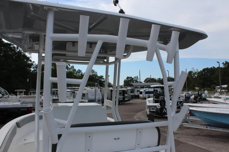 Slide: The Image of 2024 Clearwater 2200 CC boat with rod holders, parked in a marina. - 13