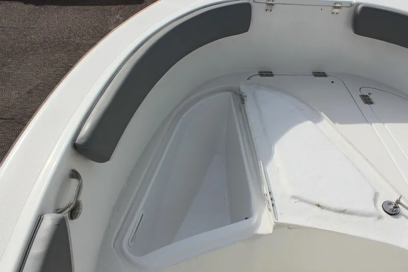 Slide: The Image of 2024 Clearwater 2200 CC boat interior with cushioned seating and storage compartment. - 21