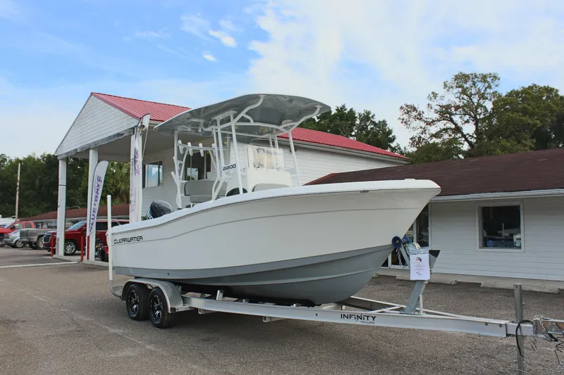 Slide: The Image of 2024 Clearwater 2200 CC boat on trailer outside dealership, clear sky background. - 4