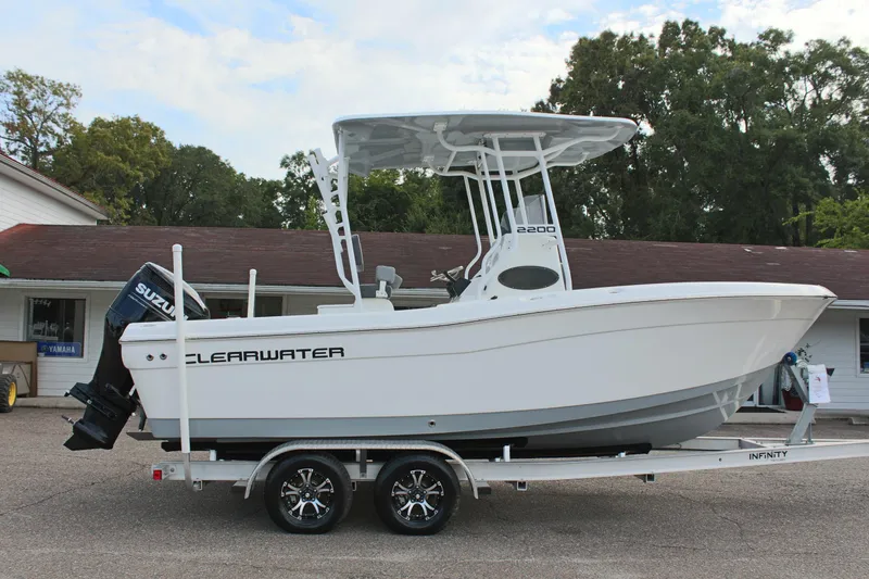 Slide: The Image of 2024 Clearwater 2200 CC boat on trailer, featuring Suzuki outboard motor, parked outdoors. - 5