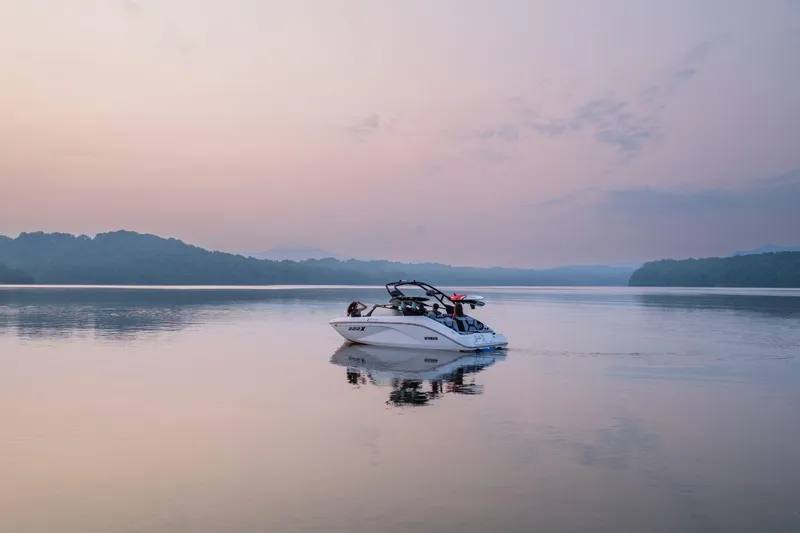 The Image of 2026 Yamaha Boats 222XD on serene lake at sunrise, surrounded by misty hills. - 0