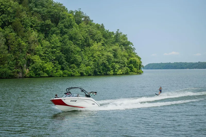 Slide: The Image of 2026 Yamaha Boats 222XD towing a wakeboarder on a scenic lake. - 19