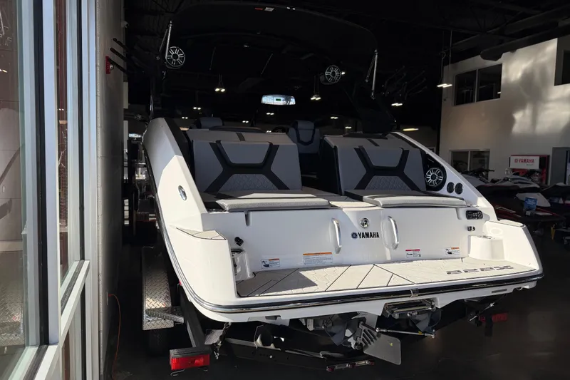 Slide: The Image of 2026 Yamaha Boats 222XD in showroom, rear view showcasing seating and design. - 25