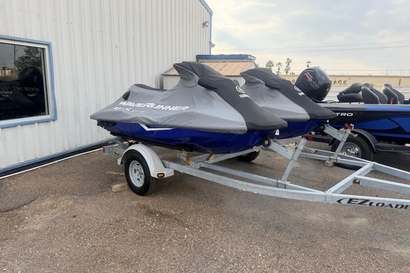 Slide: The Image of 2019 Yamaha WaveRunner EXR jet skis on trailer, covered and parked outside. - 22