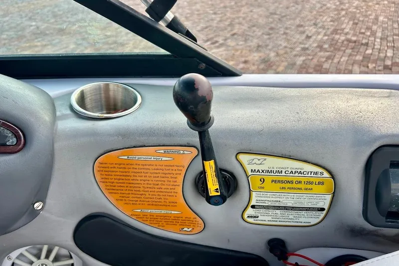 Slide: The Image of 2001 Correct Craft Air Nautique dashboard with capacity warning labels and control lever. - 11