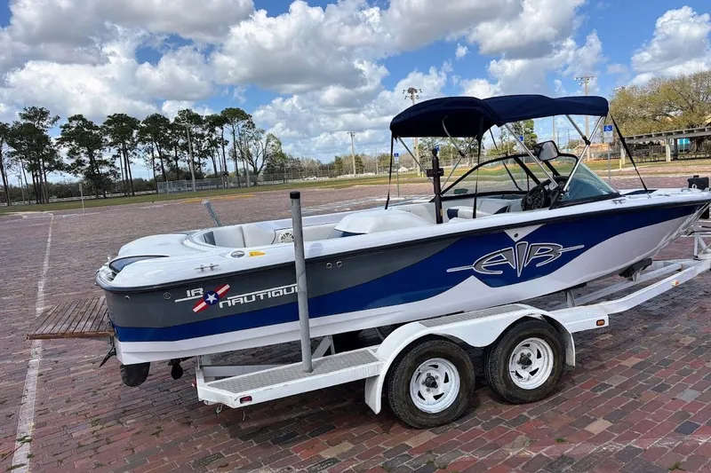 Slide: The Image of 2001 Correct Craft Air Nautique boat on trailer, parked on brick pavement under cloudy sky. - 22