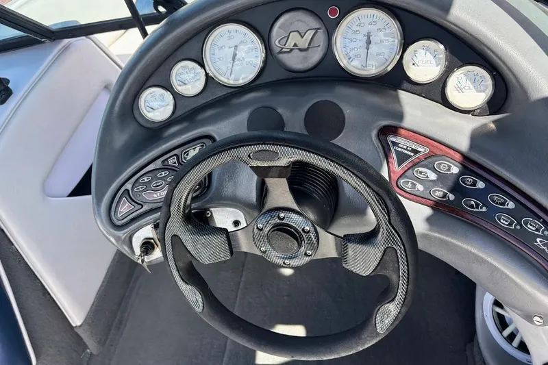 Slide: The Image of 2001 Correct Craft Air Nautique dashboard with steering wheel and gauges. - 23