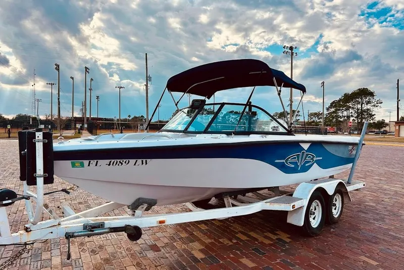 Slide: The Image of 2001 Correct Craft Air Nautique boat on trailer, parked on brick pavement under a cloudy sky. - 4