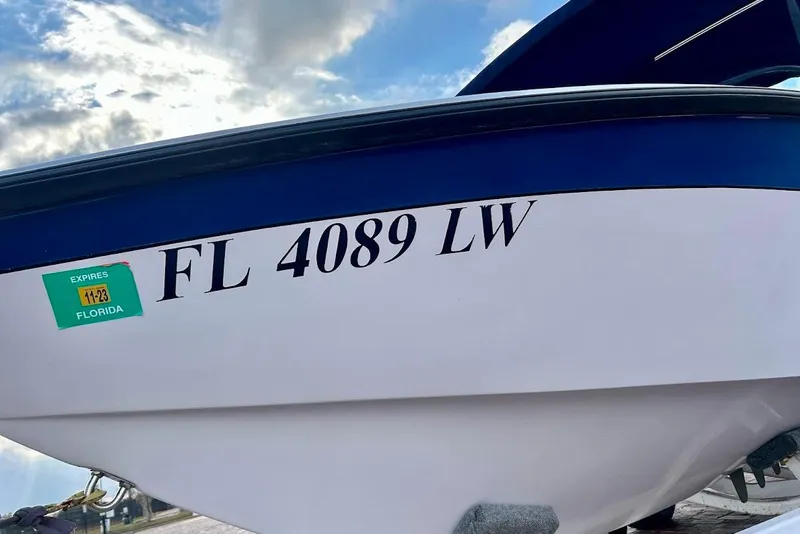 Slide: The Image of 2001 Correct Craft Air Nautique boat on trailer, parked near waterfront with palm trees. - 5