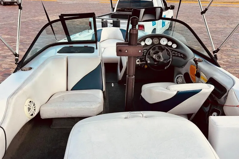 Slide: The Image of 2001 Correct Craft Air Nautique boat with white and blue interior, parked outdoors. - 8