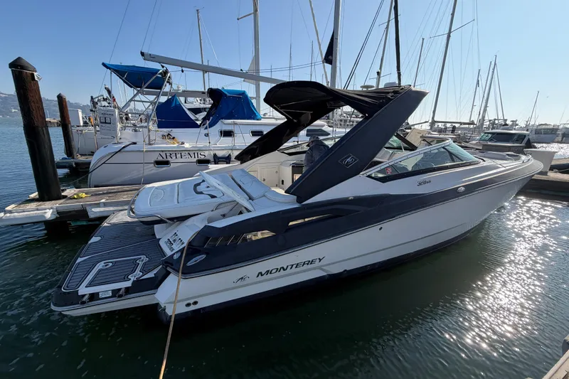 The Image of 2012 Monterey 328SS Super Sport boat docked at marina, surrounded by sailboats. - 0