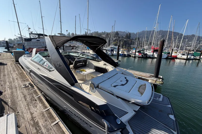 Slide: The Image of 2012 Monterey 328SS Super Sport boat docked at a marina with sailboats in the background. - 12