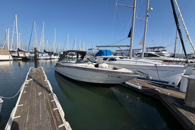 Slide: The Image of 2012 Monterey 328SS Super Sport boat docked in a marina with sailboats. - 13