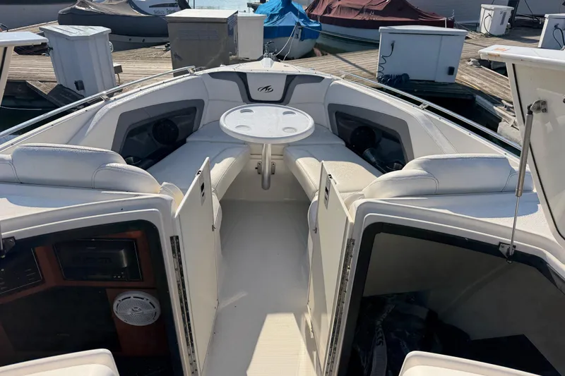 Slide: The Image of 2012 Monterey 328SS Super Sport boat interior with seating and table at dock. - 18