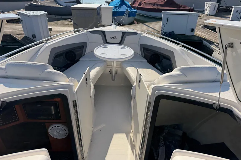 Slide: The Image of 2012 Monterey 328SS Super Sport boat interior with seating and table at dock. - 7