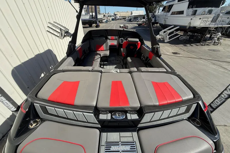 Slide: The Image of 2021 Malibu Wakesetter 23 MXZ boat interior with red and gray seating. - 11