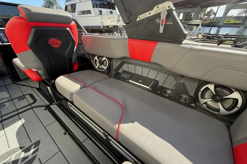 Slide: The Image of 2021 Malibu Wakesetter 23 MXZ interior with red and gray seating, speakers, and cup holders. - 22