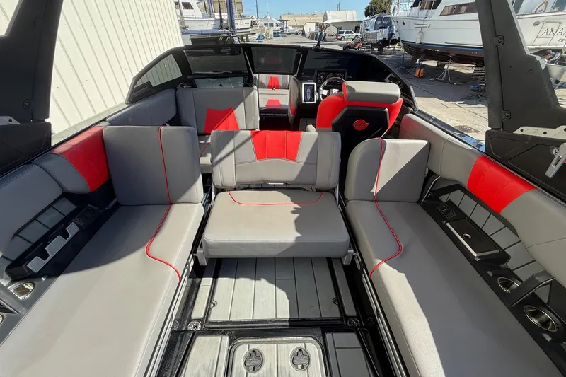 Slide: The Image of 2021 Malibu Wakesetter 23 MXZ interior with gray and red seating, spacious layout. - 25