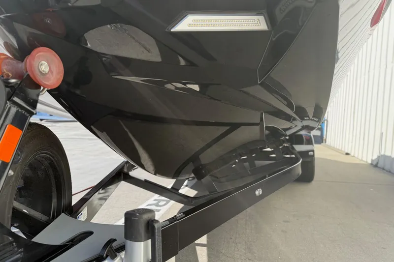 Slide: The Image of 2021 Malibu Wakesetter 23 MXZ boat on trailer, close-up view of hull and wheel. - 4