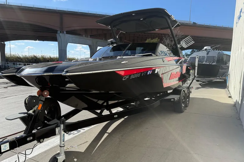 Slide: The Image of 2021 Malibu Wakesetter 23 MXZ boat on trailer under bridge. - 5
