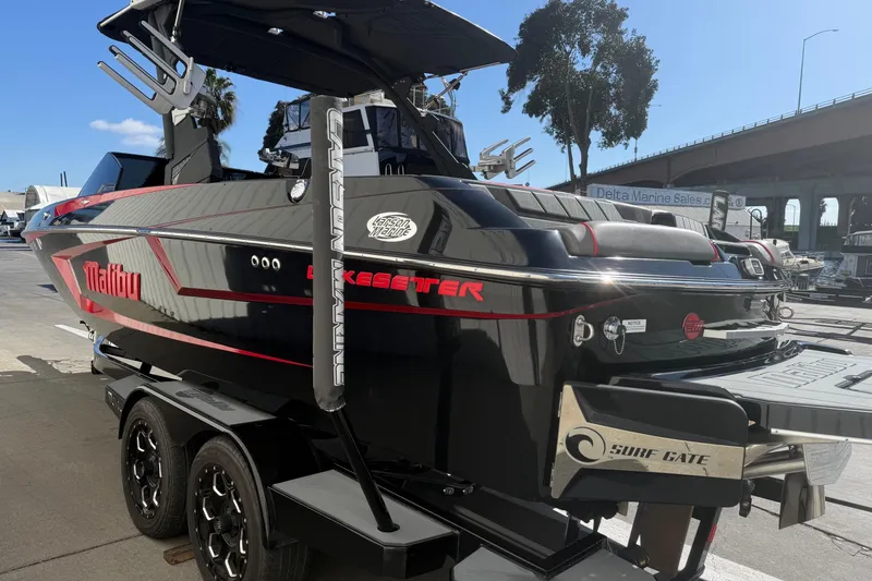 Slide: The Image of 2021 Malibu Wakesetter 23 MXZ boat on trailer, sleek black design with red accents. - 6