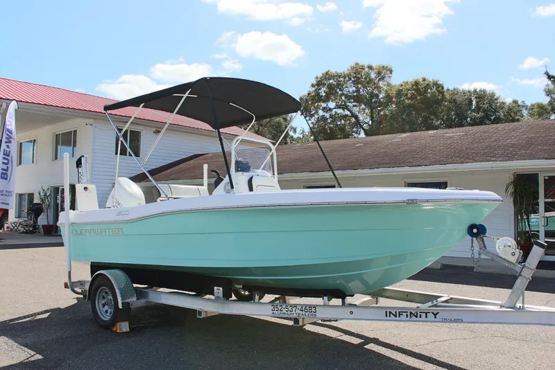 Slide: The Image of 2024 Clearwater 1900 CC boat on trailer, parked outside a building. - 4