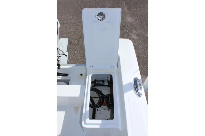 Slide: The Image of 2024 Clearwater 1900 CC boat storage compartment with open lid, showing interior equipment. - 11