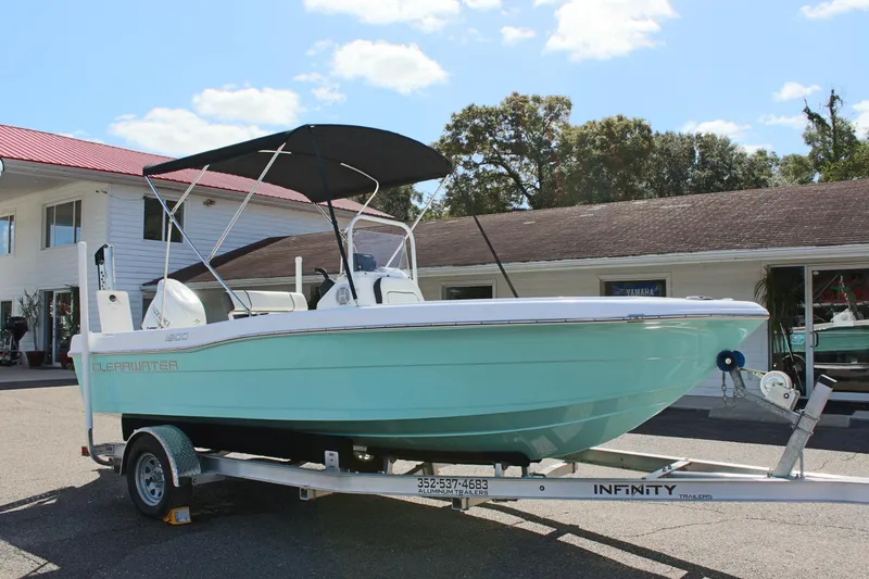 Slide: The Image of 2024 Clearwater 1900 CC boat on trailer, parked outdoors under blue sky. - 5