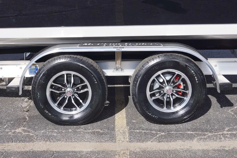 Slide: The Image of 2026 Tidewater 2410 Bay Max trailer wheels on asphalt, featuring sleek alloy rims. - 3
