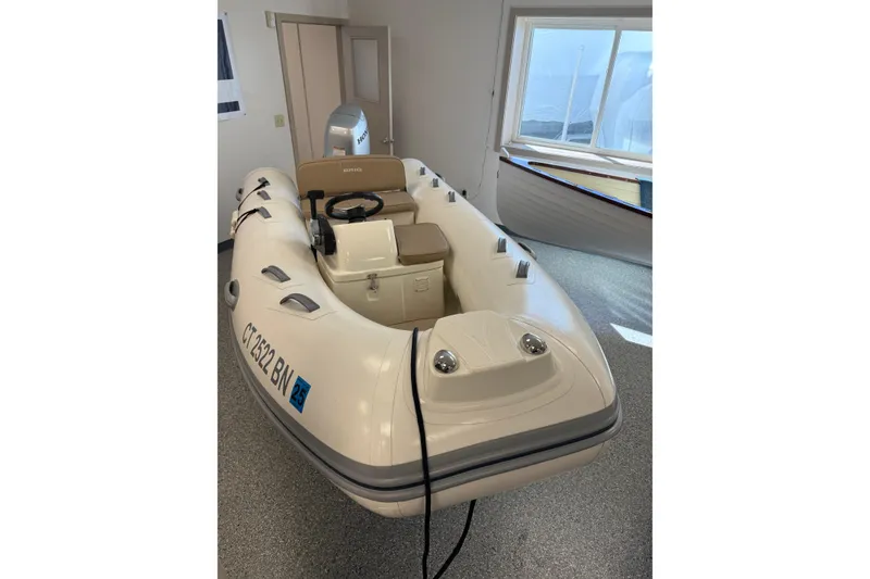 The Image of 2021 Brig Falcon 360 inflatable boat in showroom, beige interior, steering console visible. - 0
