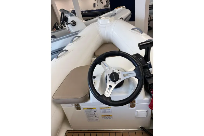 Slide: The Image of 2021 Brig Falcon 360 inflatable boat interior with steering wheel and seating. - 6