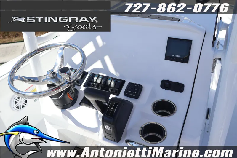 Slide: The Image of 2026 Stingray 216 CC boat dashboard with steering wheel and controls, featuring Suzuki display. - 14