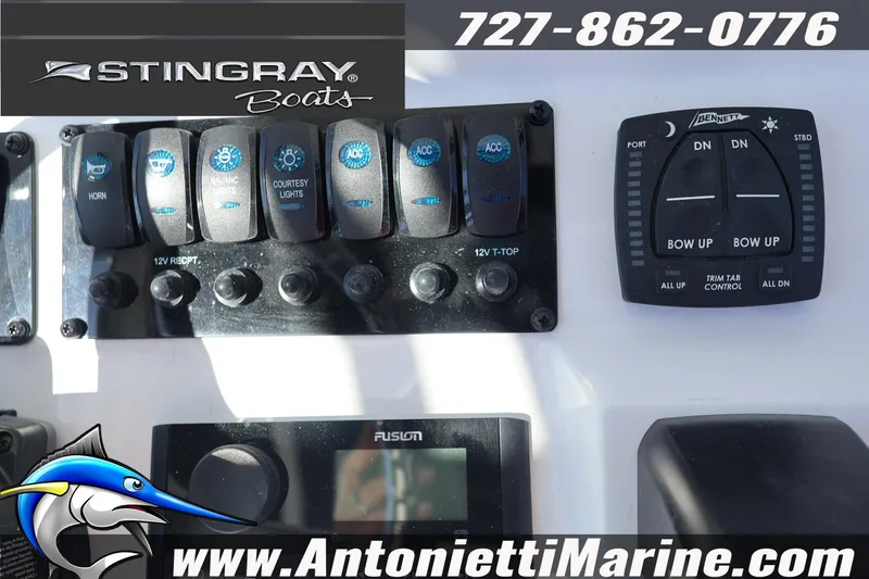 Slide: The Image of Control panel of a 2026 Stingray 216 CC boat with switches and trim tab controls. - 15
