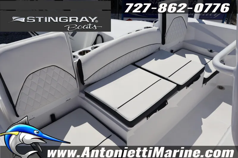 Slide: The Image of 2026 Stingray 216 CC boat interior with white seating, cup holders, and branding details. - 22