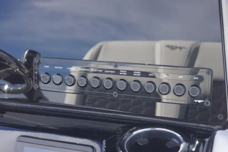 Slide: The Image of 2026 Tidewater 220 LXF boat control panel with various function buttons. - 13