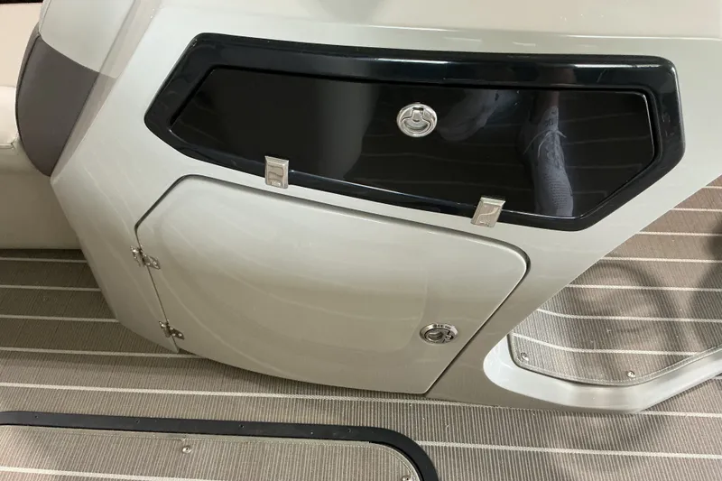 Slide: The Image of 2026 Manitou 25 Encore RF SHP boat interior storage compartment with sleek design and secure locks. - 8