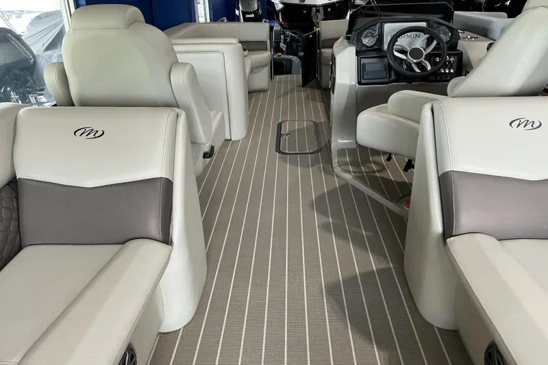 Slide: The Image of Interior of 2026 Manitou 25 Encore RF SHP boat with luxurious seating and modern dashboard. - 11