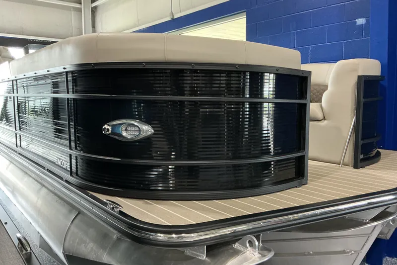 Slide: The Image of 2026 Manitou 25 Encore RF SHP pontoon boat with sleek black exterior and beige seating. - 2