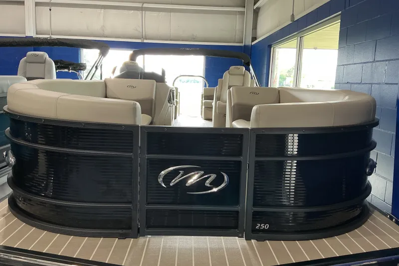 The Image of 2026 Manitou 25 Encore RF SHP pontoon boat with luxurious seating in showroom. - 1
