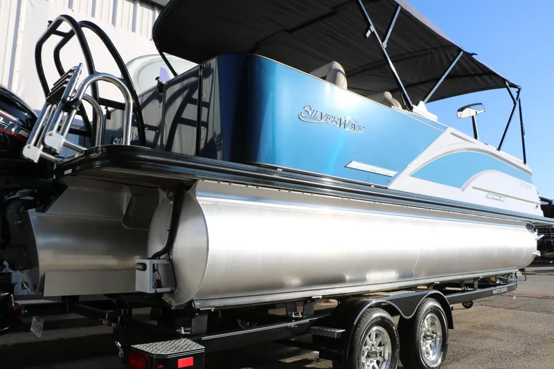 Slide: The Image of 2023 Silver Wave 2410 SW5 RLP pontoon boat with blue and white design on a trailer. - 12