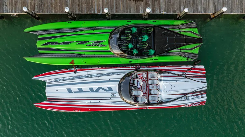 Slide: The Image of Two MTI 48 powerboats, green and red, docked side by side, aerial view. - 11