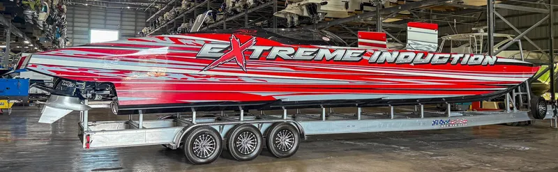 Slide: The Image of High-performance MTI 48 speedboat with vibrant red and white design in a warehouse setting. - 15