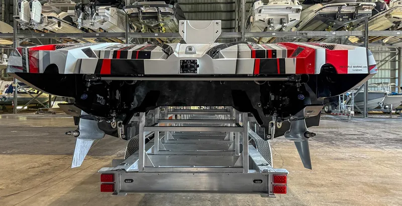 Slide: The Image of 2019 MTI 48 boat in storage, rear view showing dual propellers and vibrant design. - 18