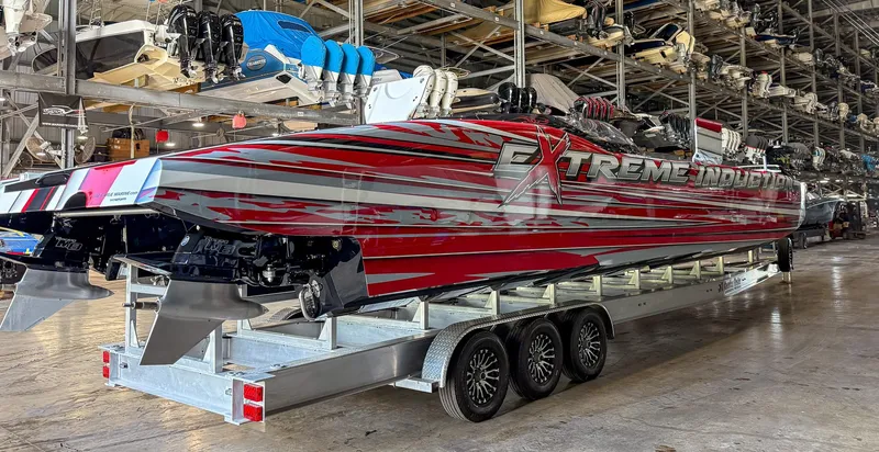 Slide: The Image of 2019 MTI 48 powerboat with vibrant red and silver design in a storage facility. - 22