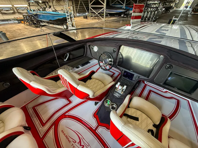 Slide: The Image of Interior of a 2019 MTI 48 boat with red and white seating and advanced dashboard. - 26