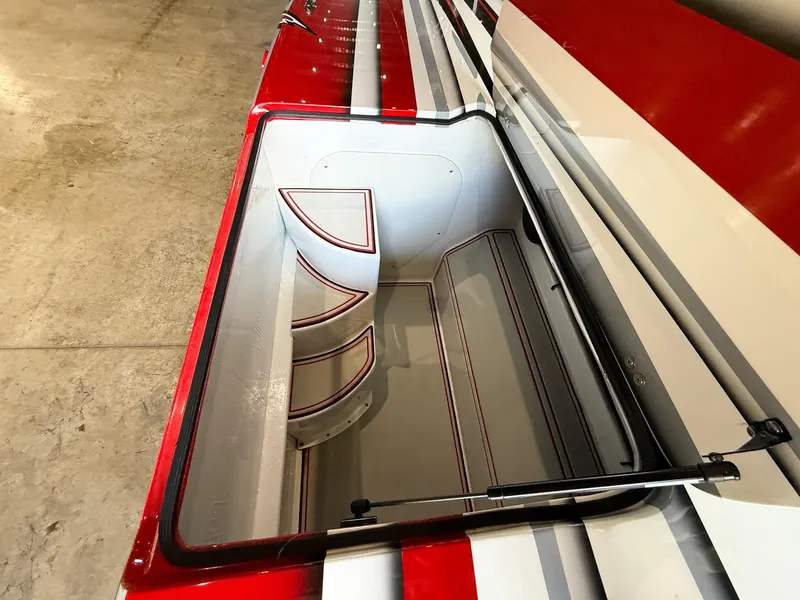 Slide: The Image of Open storage compartment in a 2019 MTI 48 boat with red and white design. - 32
