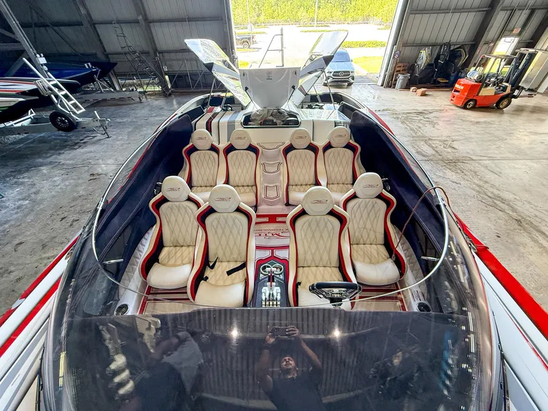 Slide: The Image of Luxury MTI 48 speedboat interior with plush seating, docked in a spacious warehouse. - 33