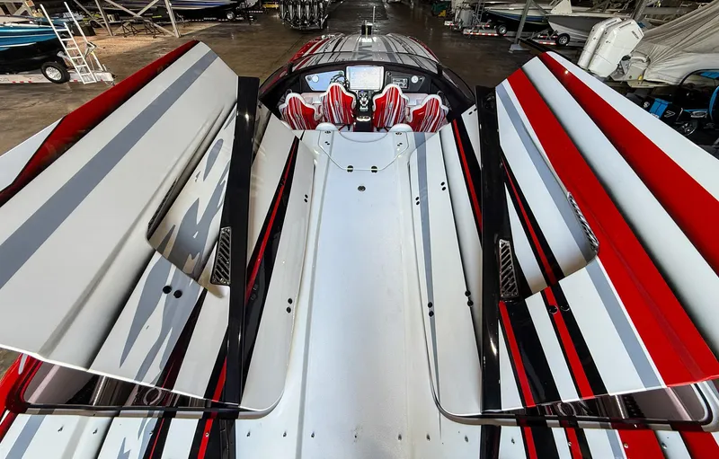 Slide: The Image of 2019 MTI 48 boat with sleek red, white, and black design in a storage facility. - 45
